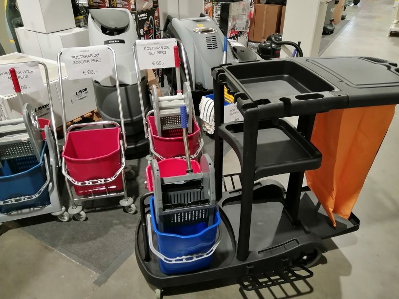 A row of janitorial carts and cleaning buckets on display in a store, including pink and blue bins and wringers.